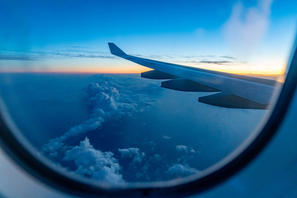 Airplane wing at sunrise suggesting last-minute travel opportunities
