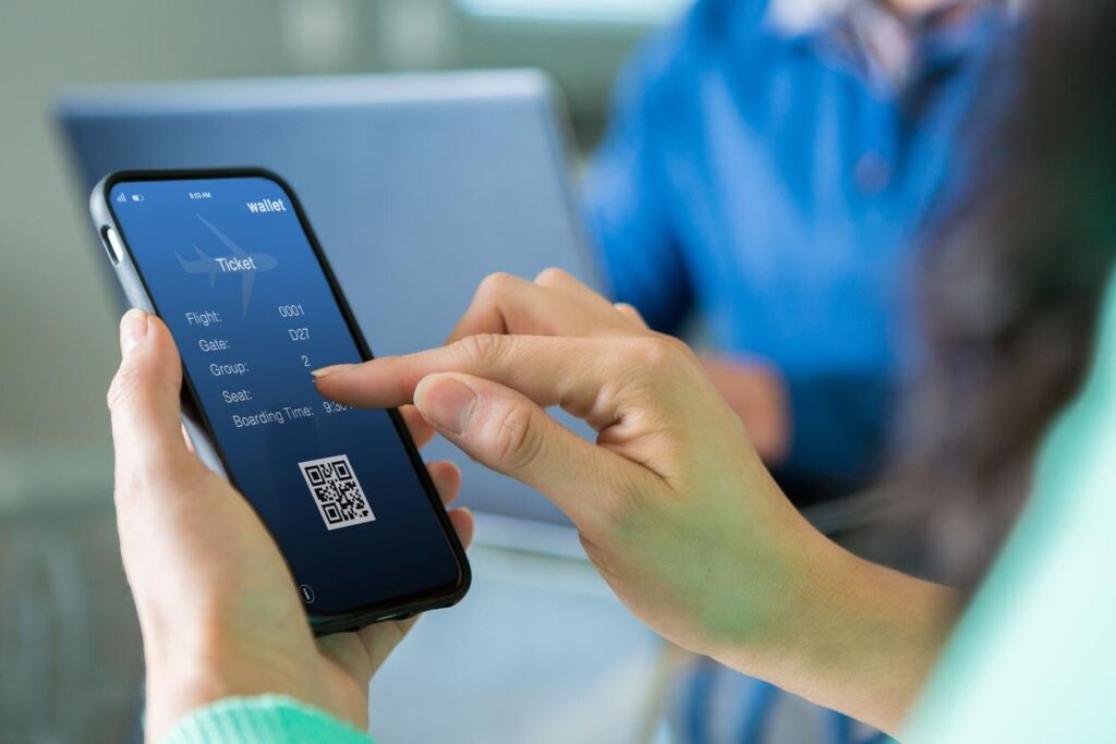 Person holding smartphone displaying digital boarding pass with flight details.