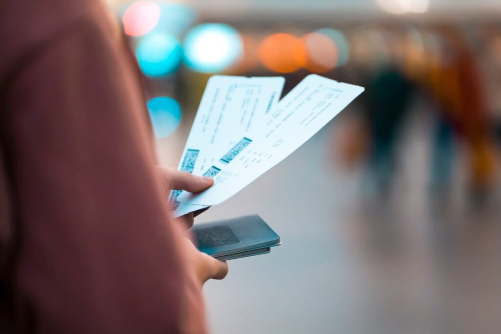 Person holding boarding passes and a passport inside an airport.